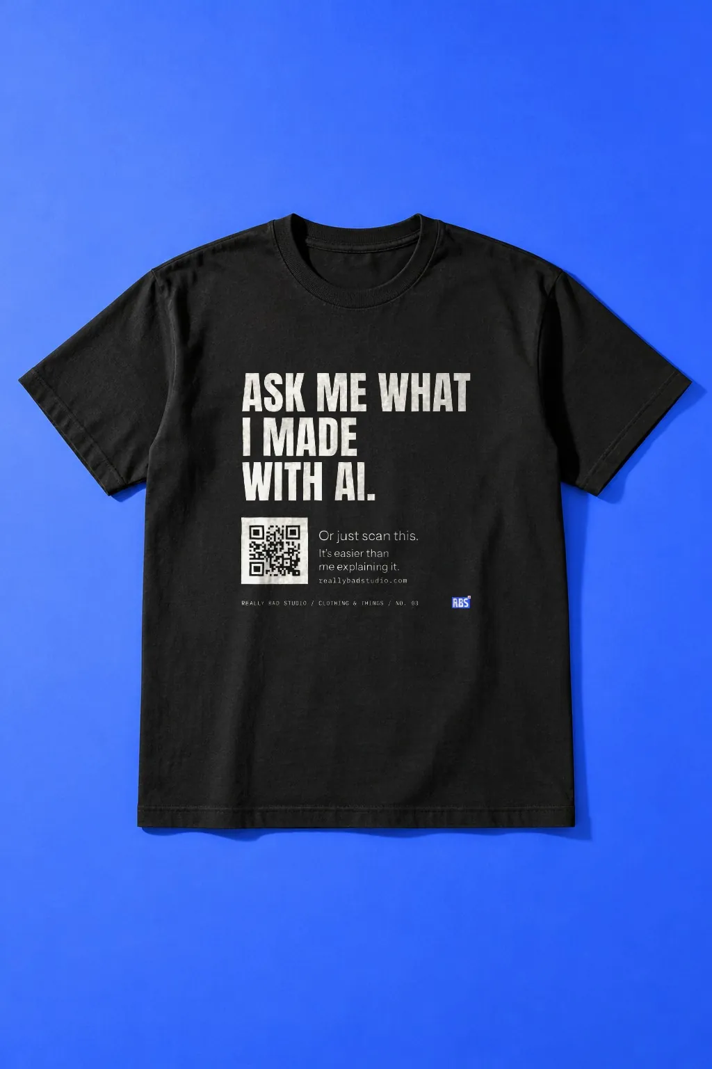 The ask me tee laid flat on cobalt blue paper.